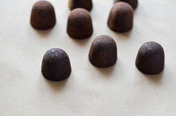 Chocolate candy truffle with chocolate pieces and flying cocoa powder on a dark background