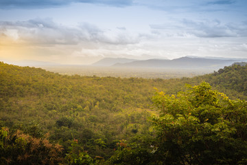 Obraz premium Peaceful landscape of green forest and sunrise or sunset over mountains in Pakse, Champasak, Laos. Shot zooms from Wat Sirindhorn Wararam Phu Prao, Ubon Ratchathani, Thailand, nearby Chong Mek border