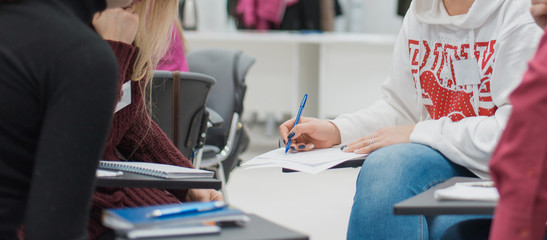 A woman sits at a lecture, presentation.