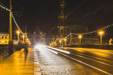 Fototapeta na wymiar Brücke bei Nacht mit Strassenpflasterung Schienen und Licht und Strassenlampen