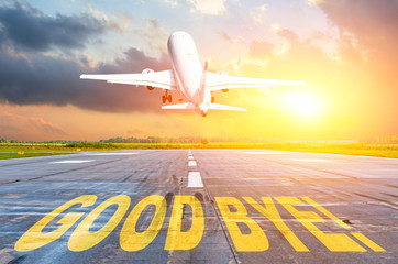 Good luck written on runway airport, and the airplane take off into the sunset. Concept of...