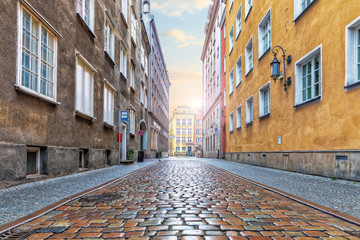 Fototapeta na wymiar Empty european street with pebble stone pavement in the downtown of Gdansk, Poland