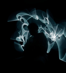 Blue-white curled line - ribbon painted by light on the black background. Improvisational painting...