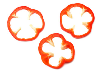 cut slices of red sweet bell pepper isolated on white background top view