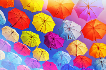 Colorful umbrellas on the sky background, toned.