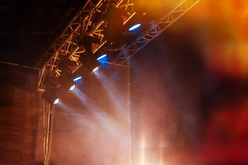 spotlights illuminate the scene in a haze of blue during the open air concert.