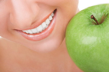 Healthy teeth and green apple. Smiling woman mouth with great white teeth. Close up. Beauty and dental health. Pretty woman smiling, whitening concept