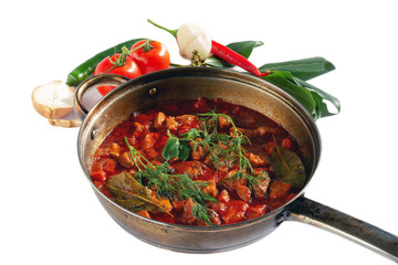 stewed meat with vegetables in tomato sauce on pan isolated on white background