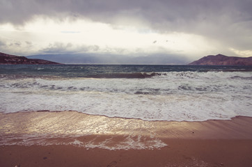 stormy sea and pebble beach in dark atmosphere