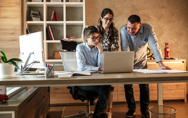A group of casually dressed business professionals collaborate in the office, exchanging ideas and fostering a dynamic work environment.