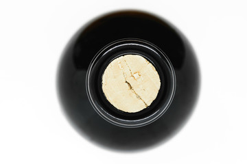 Closed with cork black glass wine bottle view from top on white background