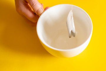 man makes a tea bag in a white cup