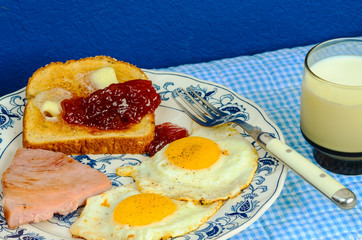 Sunny Side Eggs and Ham Breakfast with Toast and Jelly in Country Kitchen Setting