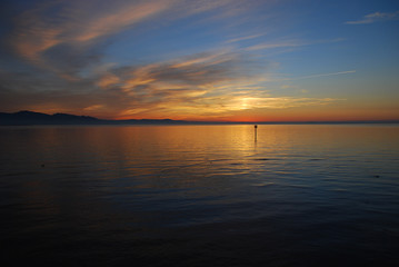 Naklejka premium Lindau, Germany: A view of the Bodensee (aka Lake Constance), in the distance Austria, and Switzerland, at sunset in the summer