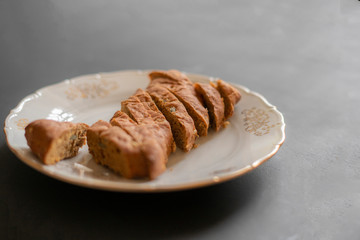 woman cuts bread with a knife in the kitchen on a wooden board