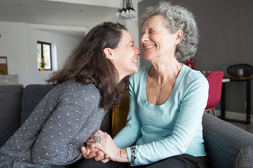 Happy elderly woman and her daughter laughing and holding hands