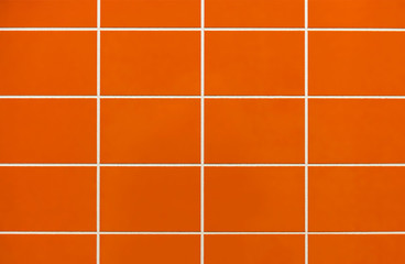 Orange ceramic tile on the wall in the bathroom. Background from orange tiles.
