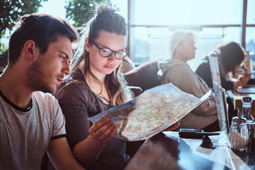 Portrait of a young couple sitting in an outdoor caf planning to itinerary their journey