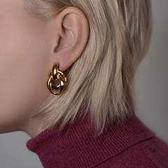 Jewelry in the form of earrings on the girl's ear close up