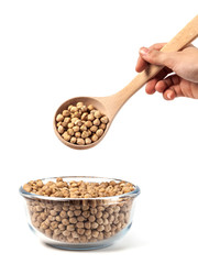 Chickpeas on glass bowl with wooden spoon on white background