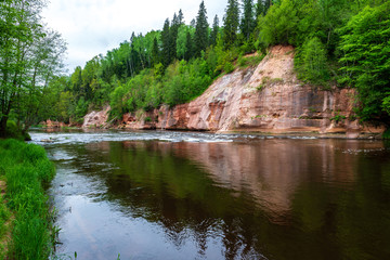 Obraz premium sandstone cliffs on the shore of forest river