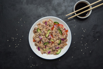 Asian Tuna Salad on the black table. Top view. 