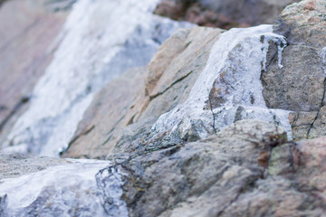 Icicles on granite rocks. Frozen water on stones. Clear water in winter. Freshwater source in mountains