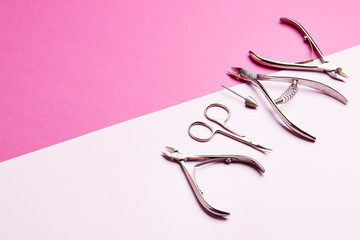 A set of tools for manicure on a pink background with a place for the text.