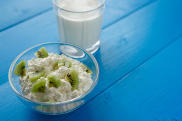 curd with kiwi and milk on a blue wooden background. healthy food concept