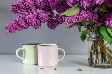 Lilac bouquet on the table with cups 