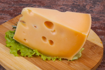 Maasdam cheese  in the board served salad leaves