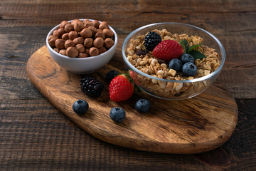 close - up of muesli with berries and nuts on wooden background