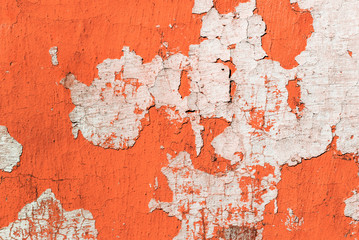 Contrast photograph of an old faded red wall with defects and remnants of fragments of light plaster of an abstract form resembling a fancy geographic map