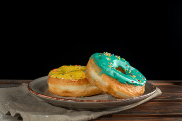 Yellow and green donuts on a designer plate.