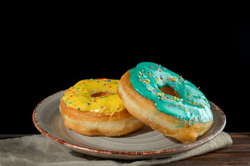 Yellow and green donuts on a designer plate.