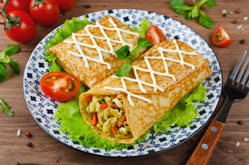 Fototapeta na wymiar Crepes stuffed with stewed cabbage with carrots and eggs.