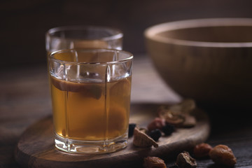 close up of fruit compote in glass cups on wooden background