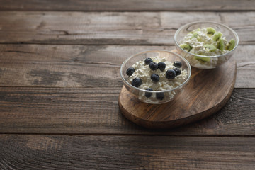 Still life with cottage cheese blueberries and kiwis on wooden stand copy space