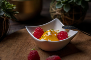Cream fruit dessert with mango passion fruit sauce and raspberries and meringue 