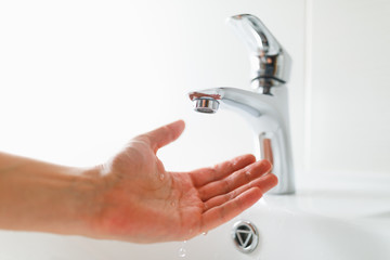 hand under faucet without water