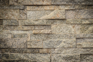 Beautiful pattern of old decorative stone wall background. Vintage stone wall Texture in weathered and have natural surfaces for design background. Featured pattern gray color of antique stone wall.