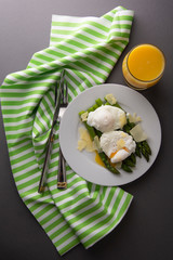 Asparagus salad with poached egg and parmesan cheese. gray background. Healthy, tasty breakfast.