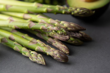 Close up of fresh green asparagus on gray table. Green vegetables, healthy food ingredients.