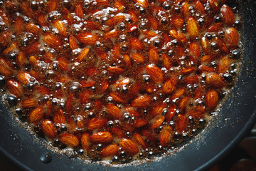 roasted almonds with cinnamon sugar cooking process, top view close-up
