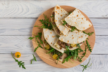 Piadina romagnola - Italian flatbread with sausages (salsiccia), rucola and onion.