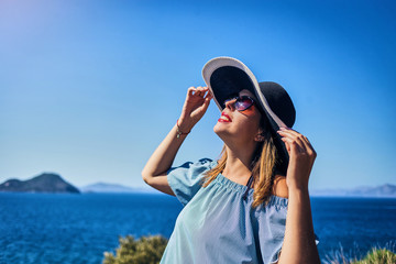 Beautiful woman in beach hat enjoying sea view with blue sky at sunny day in Bodrum, Turkey. Vacation Outdoors Seascape Summer Travel Concept