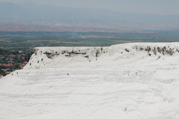 Travertine terrace formations at Pamukkale, Turkey. View of the terraces of white limestone on the mountain. Wonder of the World. Wide angle view of Pamukkale.