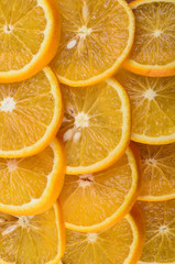 Background of ripe juicy orange slices. Textured. Vertical