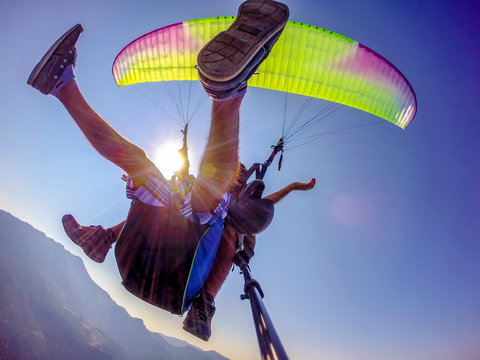 Paragliding in the sky. Paraglider tandem flying over the sea with blue water and mountains in bright sunny day. Aerial view of paraglider and Blue Lagoon in Oludeniz, Turkey. Extreme sport. Landscape