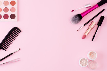 Makeup products and tools on a pink background. Frame of decorative cosmetics and accessories